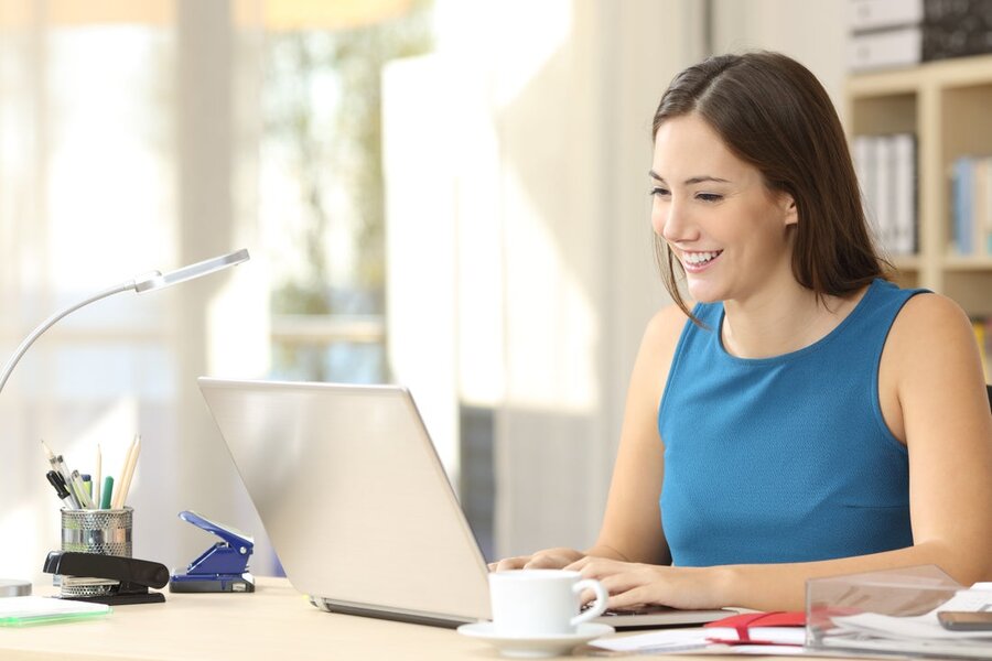 A woman at her desk using her laptop with a home network.
