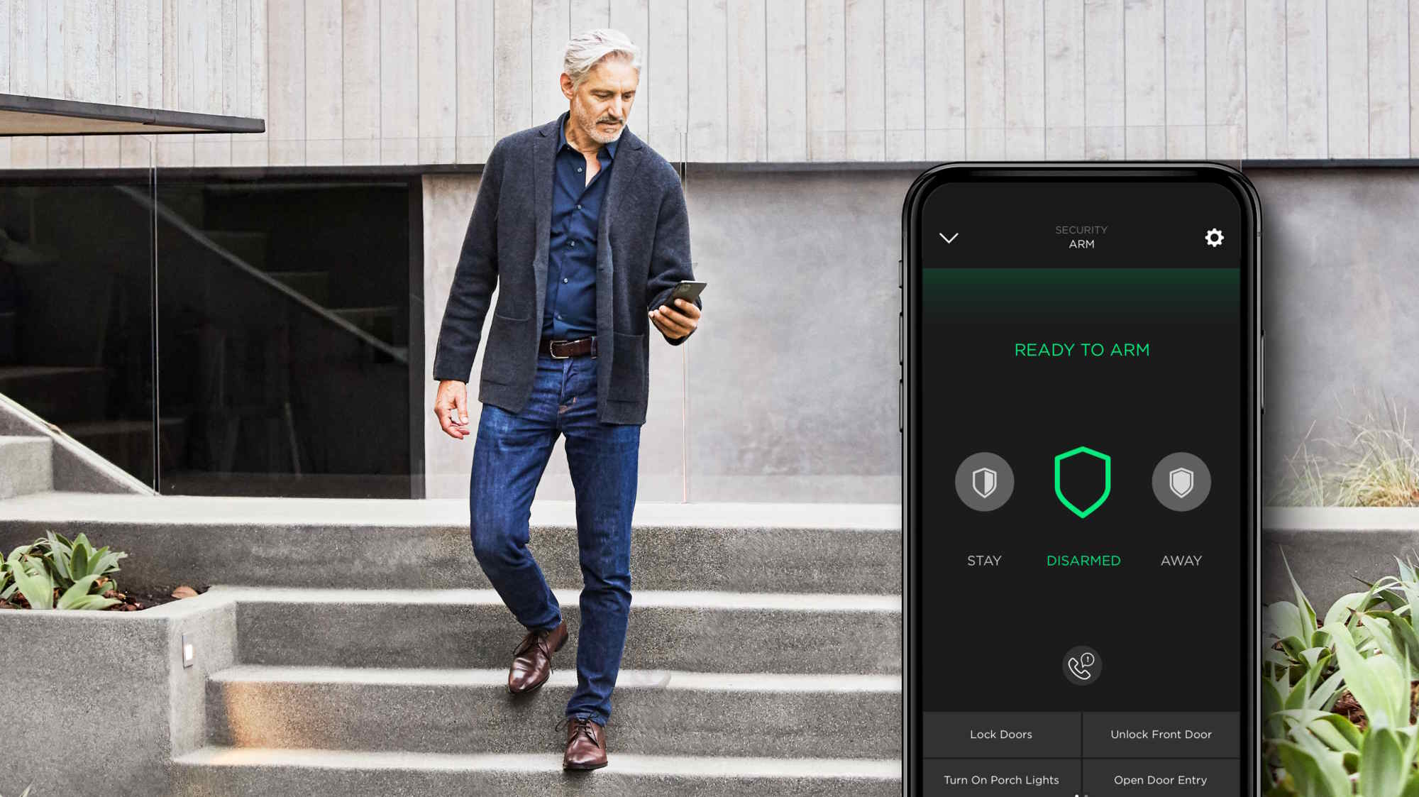 Man walking down the concrete steps of a modern home while checking his smartphone, with an overlaid security app screen showing &lsquo;Ready to Arm,&rsquo; status &lsquo;Disarmed,&rsquo; and quick actions like lock/unlock doors and turn on porch lights.