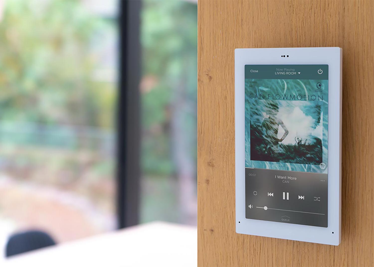 Wall-mounted touchscreen displaying Savant interface for music control
