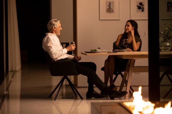 A couple enjoys dinner in a warmly lit dining room.