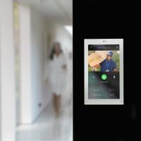Savant wall-mounted touchscreen shows surveillance footage from a patio&rsquo;s video doorbell.