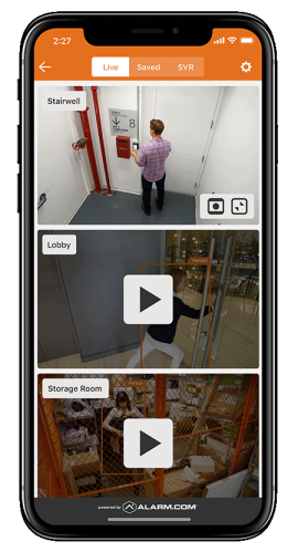 A mobile device displaying the Alarm.com app&rsquo;s live video monitoring feature, highlighting security camera feeds for a business.
