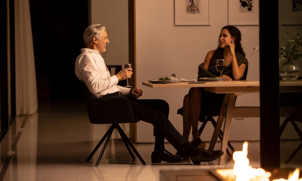 <span class="uk-h4">A couple enjoys dinner in a warmly lit dining room.</span>