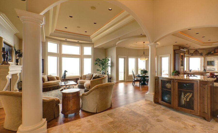 An open living space featuring in-ceiling whole-home audio speakers and a media room setup next to a kitchen area.
