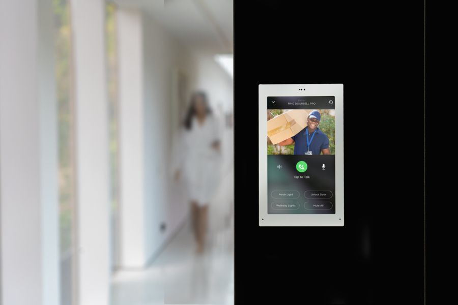 Savant wall-mounted touchscreen shows surveillance footage from a patio’s video doorbell.